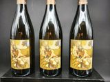 trois bouteilles de vin posées sur un bloc de bois