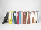 plusieurs livres sont alignés sur une surface blanche