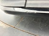 a close up of a car ' s bumper with rust on it