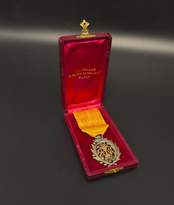medal in a red case on a black surface with a gold star