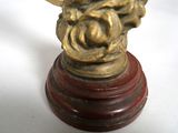 a gold clock sitting on top of a wooden stand