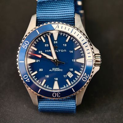 un gros plan d'une montre avec un bracelet bleu