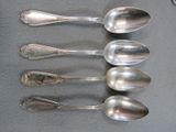 six spoons are lined up in a row on a table