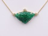 a close up of a green jade and diamond necklace on a gold chain