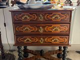a small chest of drawers in the corner of a room