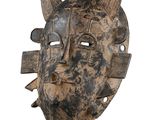 a close up of a wooden mask with horns on a white background