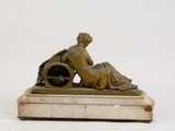 a bronze statue of a woman sitting on a marble base