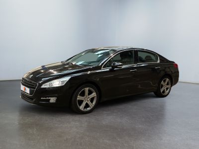 the black car is parked in a large room with a white wall