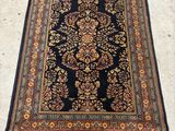 a black and gold rug with a floral design on it