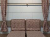 two couches in a room with curtains on the wall