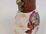 a small vase with a flower on it sitting on a table