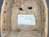 an old wooden bowl with a tag on it sitting on top of a table