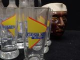 four glasses and a jug sitting next to each other