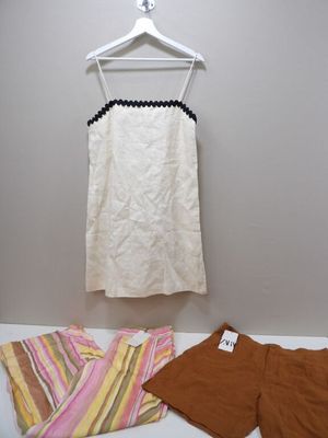 un haut blanc et un short marron sur un cintre