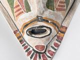 a close up of a painted mask on a wall