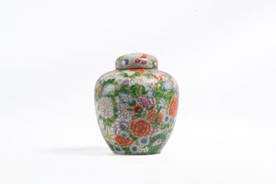 une image représentant un petit vase muni d'un couvercle, posé sur une surface blanche