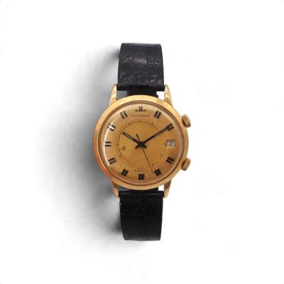 une image d'une montre en or avec des chiffres romains sur le cadran