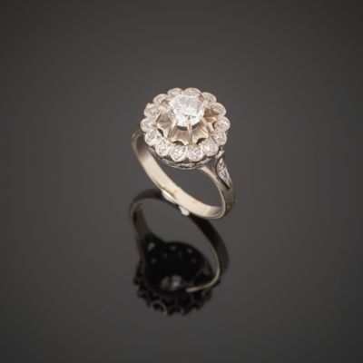 a white gold and diamond ring on a reflective surface