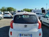 a small white car that is parked in a parking lot