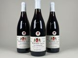 trois bouteilles de vin rouge sont alignées sur une table