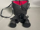 un sac noir avec une poche rouge et une paire de jumelles
