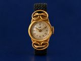 a gold wrist watch with a black band on a blue surface