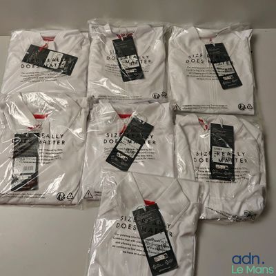 six paires de t-shirts blancs posées sur une table