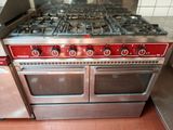 a red stove with four burners in a kitchen