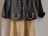 une veste noire et une jupe beige accrochées au mur