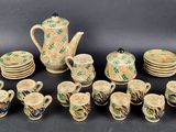 many pieces of pottery that are sitting on a table