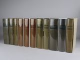 several books are lined up in a row on a white surface
