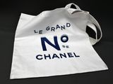 a white tote bag with the words chanel on it
