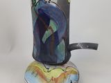 a cup with a handle that has a painting on it