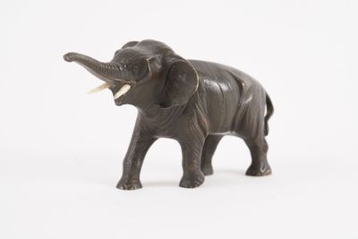 une figurine d'éléphant posée sur une surface blanche