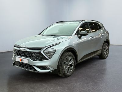 Le SUV argenté est garé dans une pièce blanche au sol noir.