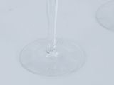two wine glasses sitting on a table with a clock on it