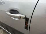 a close up of a car door handle with a sticker on it
