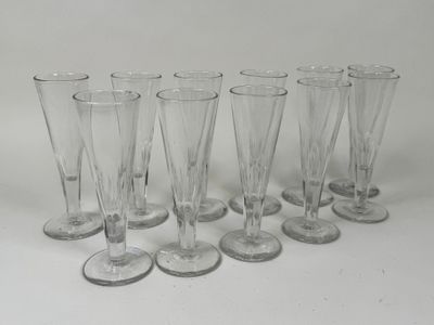 six verres à vin transparents alignés sur une surface blanche