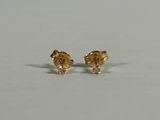 a pair of gold and diamond earrings on a white surface