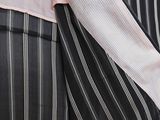 a woman in a pink shirt and black and white striped pants