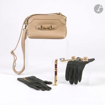 un sac à main, des gants et une paire de gants posés sur une table
