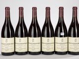 six bouteilles de vin sont alignées sur une table