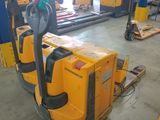 yellow forklifts are lined up in a warehouse with other forklifts in the background