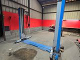 a couple of blue lifts in a building with red walls