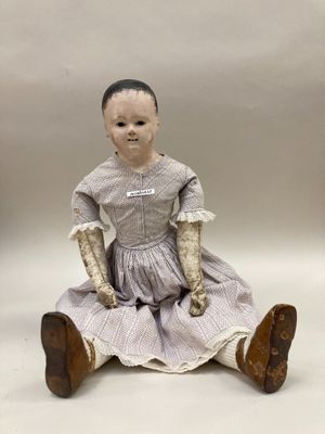 une petite poupée assise par terre