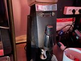a coffee maker sitting on a counter next to a cup of coffee