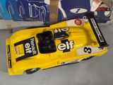 a yellow toy car that is sitting next to a box