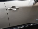 a close up of a car door handle with a cat in the background