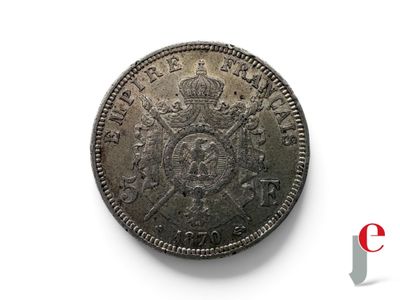une pièce d'argent sur laquelle est représentée une couronne, posée sur une surface blanche