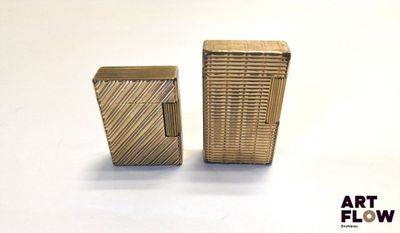 deux briquets dorés posés l'un à côté de l'autre sur une surface blanche